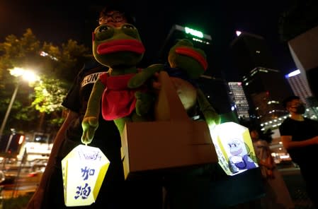 A man holds Pepe the Frog plush toys as they gather at Lennon Wall at Admiralty district during the Mid-Autumn Festival, in Hong Kong