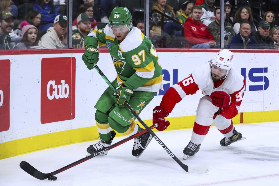 Minnesota Wild left wing Kirill Kaprizov, left, and Detroit Red Wings defenseman Jake Walman (96) compete for the puck during the second period of an NHL hockey game Wednesday, Dec. 27, 2023, in St. Paul, Minn. (AP Photo/Matt Krohn)