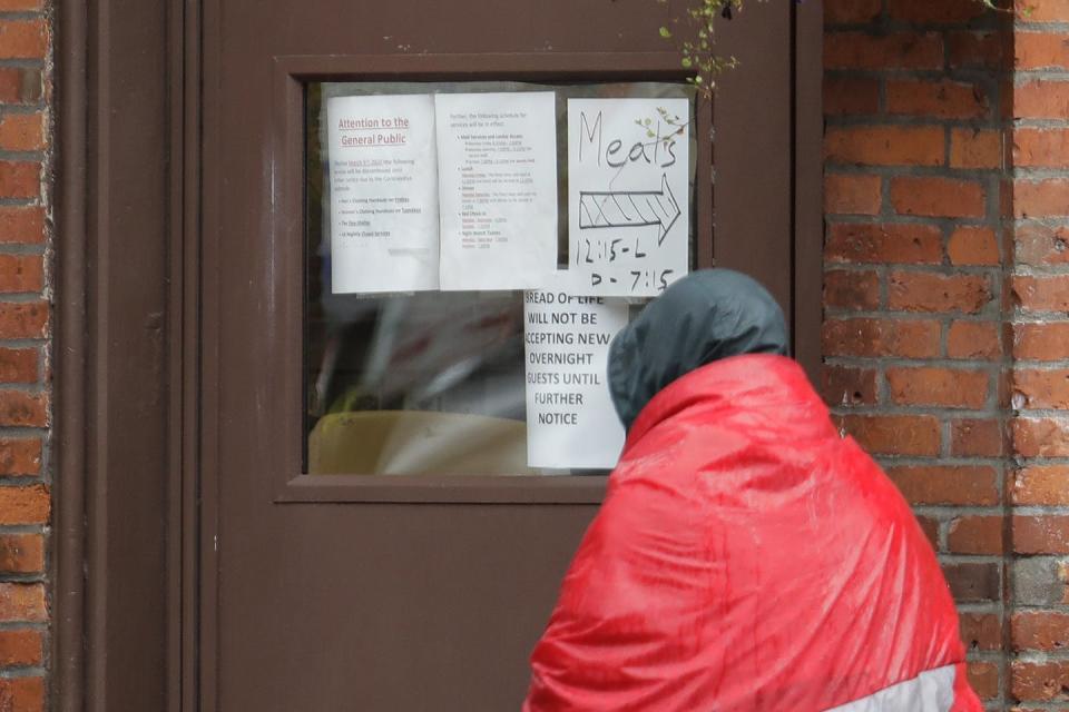 <span class="caption">A man experiencing homelessness arrives at a shelter in Pioneer Square in Seattle on March 30, 2020, to find a sign that says the shelter is not accepting new overnight guests.</span> <span class="attribution"><a class="link " href="http://www.apimages.com/metadata/Index/Virus-Outbreak-Washington-State/3d1896b6147e454693e82654788637dc/39/0" rel="nofollow noopener" target="_blank" data-ylk="slk:APPhoto/Ted S.Warren;elm:context_link;itc:0;sec:content-canvas">APPhoto/Ted S.Warren</a></span>