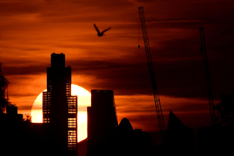 The Sun is seen rising behind skyscrapers of the City of London financial district, as the spread of the coronavirus disease (COVID-19) continues in Britain, June 2, 2020. REUTERS/Toby Melville