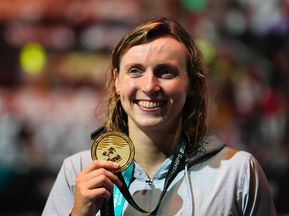 Katie Ledecky poses with her gold medal from the 800m freestyle.