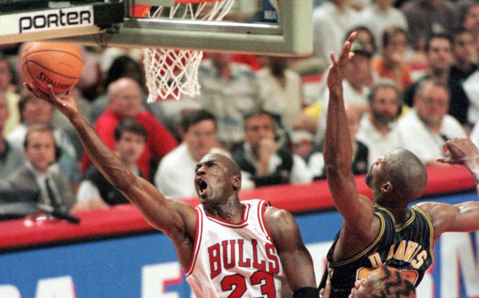 Chicago Bulls' Michael Jordan drives for the score past Indiana Pacers' Dale Davis (32) during the second quarter of Game 7 of the Eastern Conference Finals Sunday, May 31, 1998, in Chicago. Jordan became the NBA's all-time leading playoff scorer during the first half. His 5,758 points trailed Kareem Abdul-Jabbar by 5  at the start of the game and he scored 15 in the first half. (AP Photo/Mike Fisher)