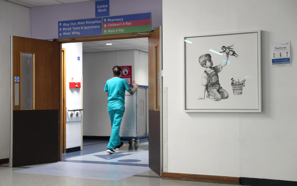 A person walks past the new artwork painted by Banksy during lockdown, entitled 'Game Changer', which has gone on display to staff and patients on Level C of Southampton General Hospital. (Photo by Andrew Matthews/PA Images via Getty Images)