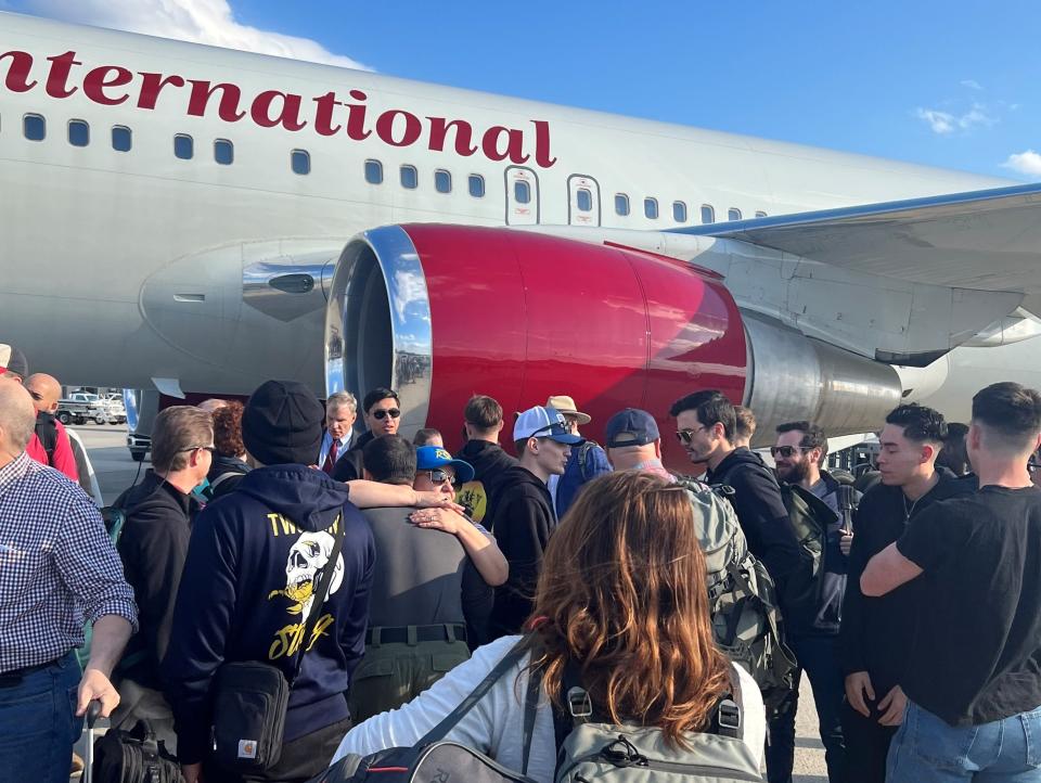 US Mission personnel assigned to the US Embassy in Khartoum, Sudan, embrace each other upon their safe return to the United States at Dulles International Airport, Va., on April 24.