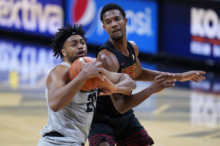 Colorado forward Evan Battey, left, pulls in a rebound as Southern California forward Evan Mobley defends during the first half of an NCAA college basketball game Thursday, Feb. 25, 2021, in Boulder, Colo. (AP Photo/David Zalubowski)