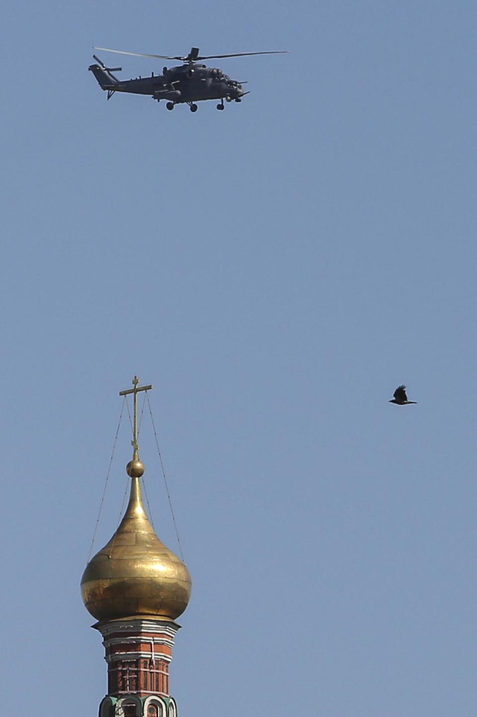 A Russian military helicopter Mi-35 flies over St. Basil Cathedral during the Victory Day parade parade in Red Square in Moscow, Russia, Friday, May 9, 2014. Russia marked the Victory Day on May 9 holding a military parade at Red Square. (AP Photo/Denis Tyrin)
