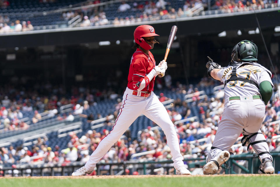 Washington Nationals' CJ Abrams, left, reacts after being hit by a pitch from Oakland Athletics starter Ken Waldichuk during the second inning of a baseball game, Sunday, Aug. 13, 2023, in Washington. (AP Photo/Stephanie Scarbrough)