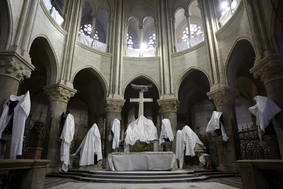 Statues protected by a tarpaulin are seen in the choir Notre Dame de Paris cathedral, Friday, Dec. 8, 2023 in Paris. Emmanuel Macron is visiting Notre Dame Cathedral on Friday, marking the one-year countdown to its reopening in 2024 following extensive restoration after the fire four years ago. Macron's visit, continuing his annual tradition since the blaze on April 15 2019, is aimed to highlight the progress in the works, including the near completion of the cathedral spire. (Sarah Meyssonnier, Pool via AP)