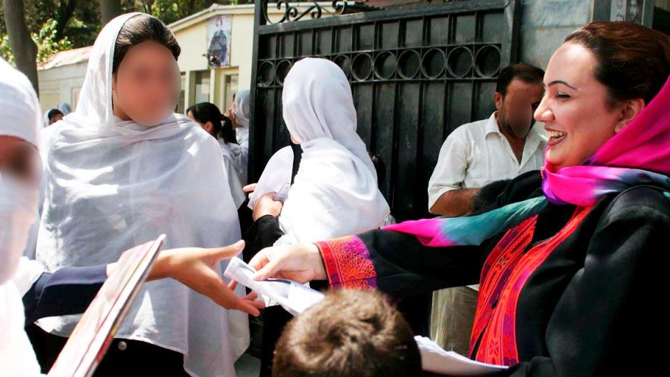 Shukria Barakzai distribuyendo panfletos electorales a niñas escolares en su campaña para las elecciones legislativas en Kabul en agosto de 2005.