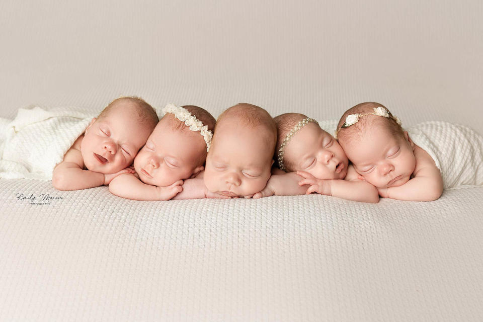 five newborn babies sleep on a white blanket (Emily Moncus / Emily Moncus Photography)