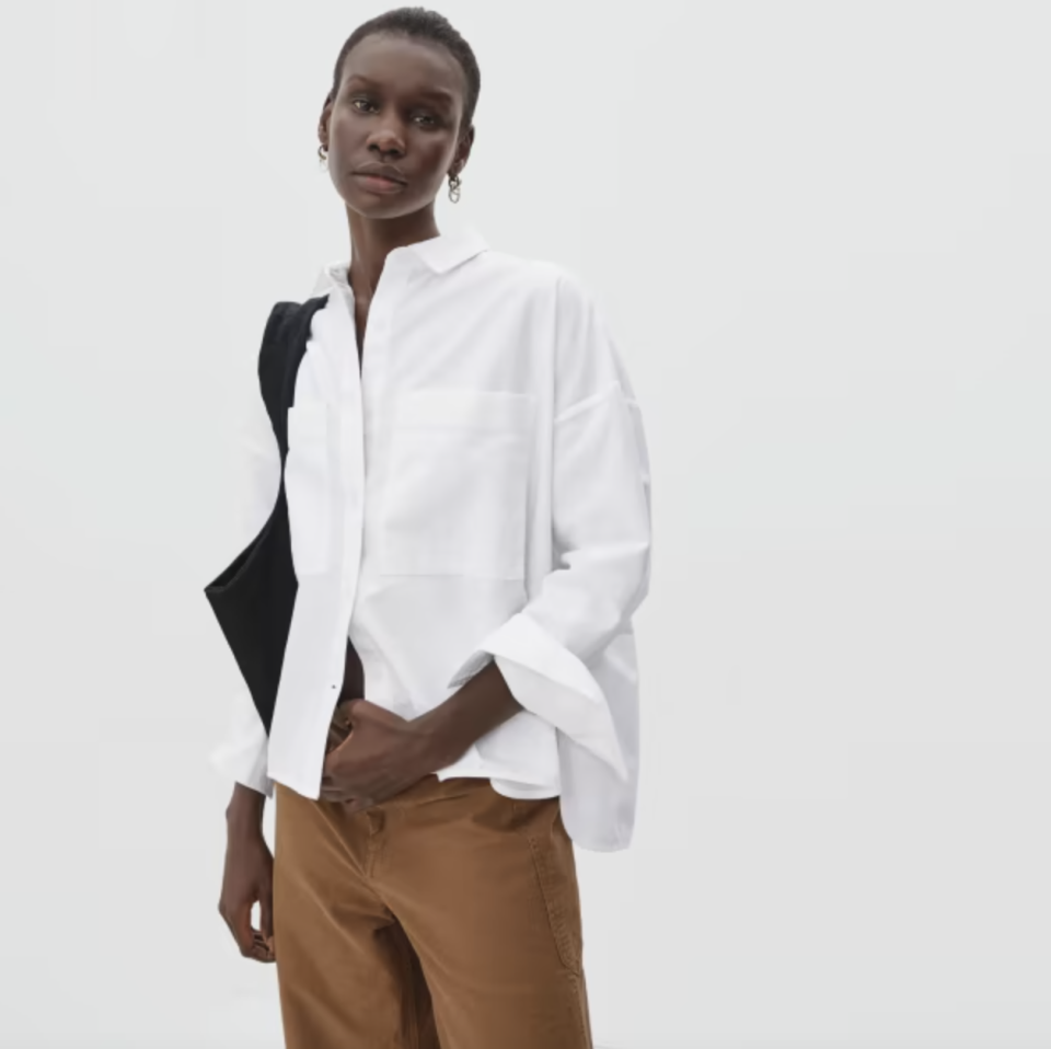 black model in brown pants and white button-down shirt The Boxy Oxford (Photo via Everlane)