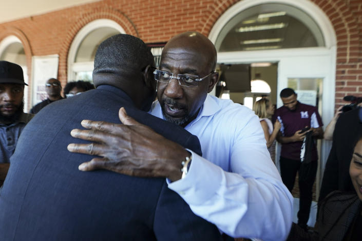 Democratic nominee for U.S Senate Sen. Raphael Warnock embraces a supporter during a campaign stop on the campus of Morehouse College Tuesday, Nov. 8, 2022, in Atlanta. (AP Photo/John Bazemore)