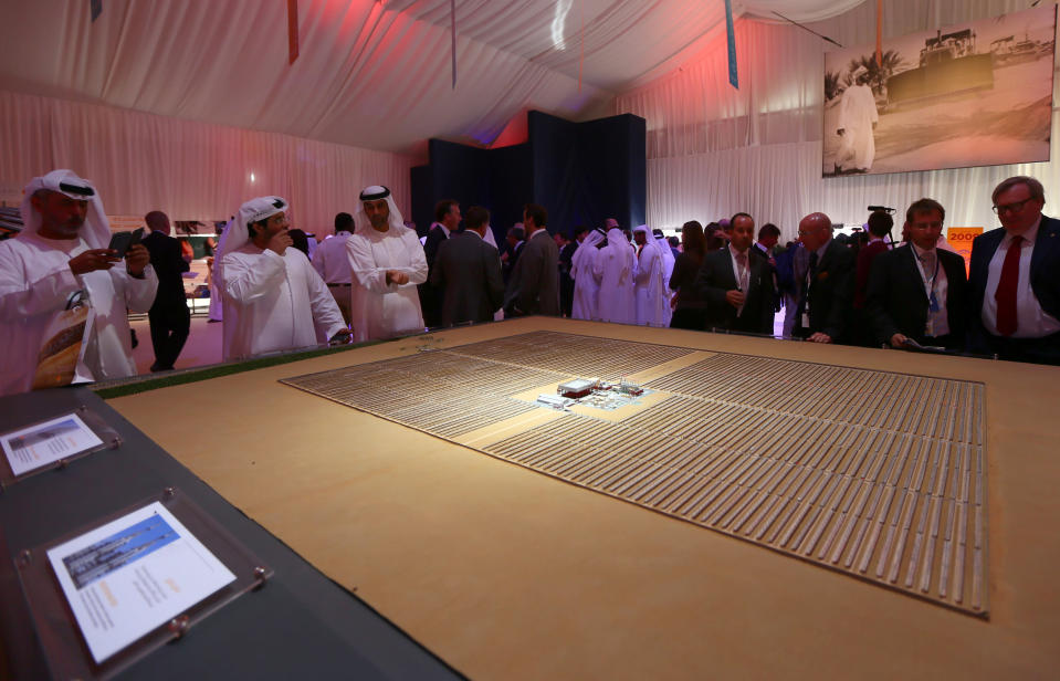 Emaratis and foreigners look at a model of the Shams 1, Concentrated Solar power (CSP) plant, in al-Gharibiyah district on the outskirts of Abu Dhabi, on March 17, 2013 during the inauguration of the facility. (MARWAN NAAMANI/AFP/Getty Images)