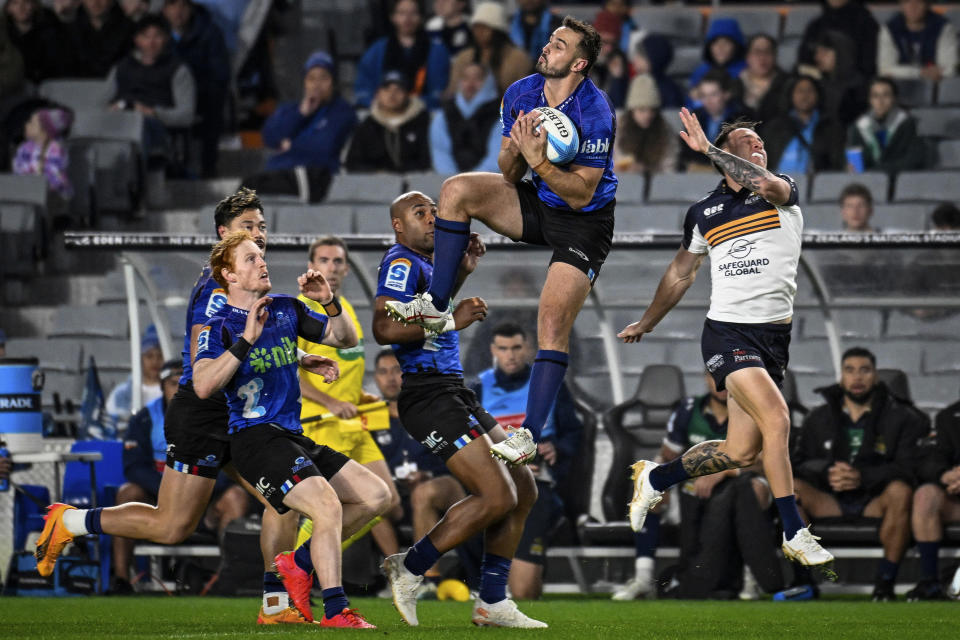 Harry Plummer of the Blues, center, takes a high ball during their Super Rugby Pacific semi-final match against the Brumbies at Eden Park in Auckland, New Zealand, Friday, June 14, 2024. (Andrew Cornaga/Photosport/AAP Image via AP)