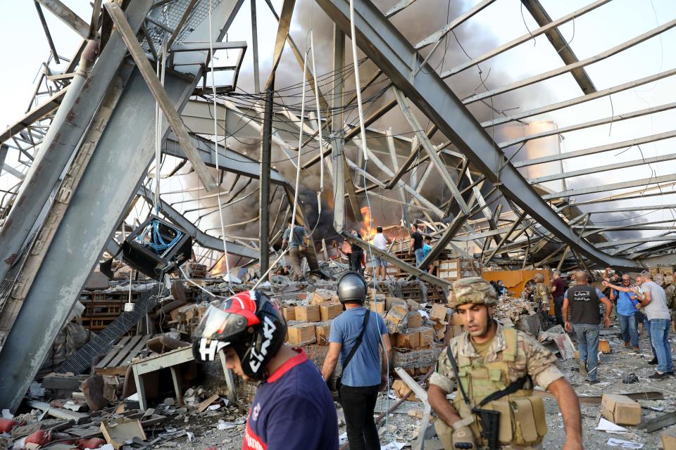 EDITORS NOTE: Graphic content / People gather at site of an explosion in the Lebanese capital Beirut on August 4, 2020. - Two huge explosion rocked the Lebanese capital Beirut, wounding dozens of people, shaking buildings and sending huge plumes of smoke billowing into the sky. Lebanese media carried images of people trapped under rubble, some bloodied, after the massive explosions, the cause of which was not immediately known. (Photo by ANWAR AMRO / AFP) (Photo by ANWAR AMRO/AFP via Getty Images)