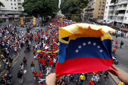 Partidarios del Gobierno de Nicolás Maduro en Venezuela (de rojo en la imagen), marchando frente a opositores en la llamada "la madre de todas las movilizaciones", en Caracas, abr 19, 2017. Un joven fue herido de bala el miércoles, dijeron testigos de Reuters, durante una nueva jornada de protestas opositoras en Caracas en contra del presidente Nicolás Maduro. REUTERS/Carlos Garcia Rawlins