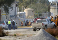 Firefighters and other officials congregate by a chemical transfer station where a chemical spill near a MGP Ingredients plant caused a toxic cloud that injured 34 people and forced an evacuation in downtown Atchison, Kansas, U.S., October 21, 2016. REUTERS/Dave Kaup