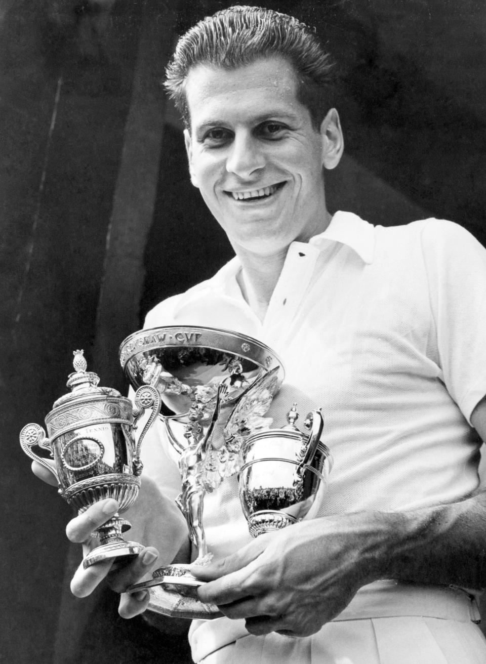 FILE - Dick Savitt of Orange, N.J., holds the three cups presented to him after winning the men's singles title at the All-England Lawn Tennis Championships in Wimbledon, England, on July 7, 1951. Savitt, who won the Australian Open and Wimbledon in 1951 shortly before walking away from a tennis career at age 25, passed away at home in New York on Friday, Jan. 6, 2023. He was 95. (AP Photo/Leslie Priest, File)