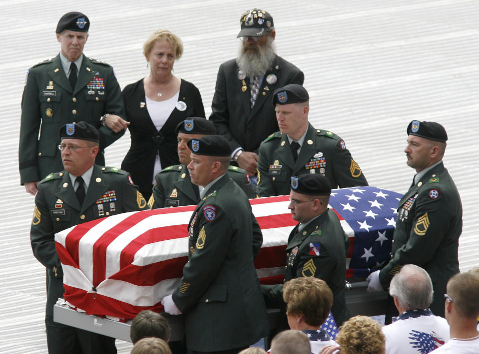 FILE - In this April 27, 2008 file photo, Lt. General James Campbell (Ret.), left, stands with Carolyn and Keith Maupin, as the casket of their son, U.S. Army Staff Sgt. Matt Maupin, is carried to a hearse during a memorial service at Great American Ball Park in Cincinnati. A man in Iraqi custody has confessed to killing Maupin, whose remains were found in 2008, four years after he was kidnapped by insurgents. (AP Photo/David Kohl, File)