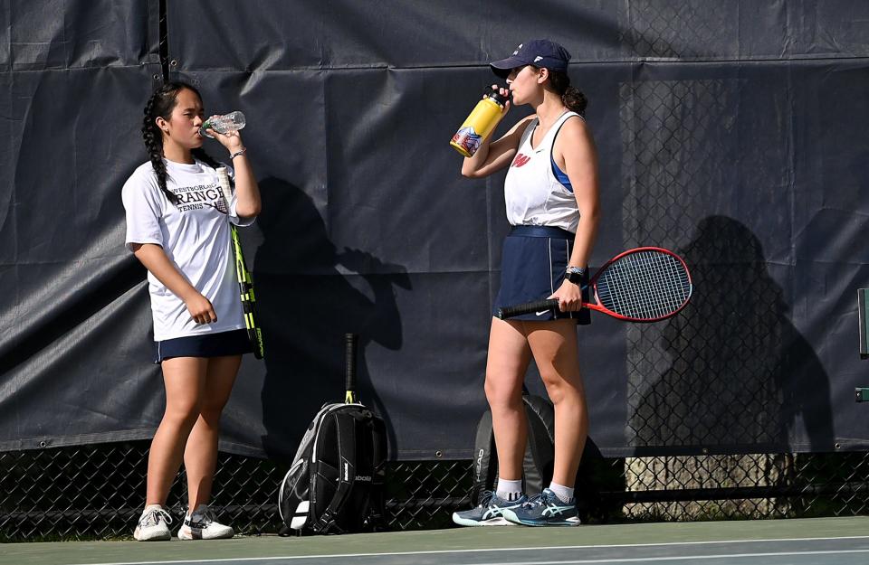 Westborough second doubles players Elena Chen, left, and Ellie King take a water break during their match against Walpole at Westborough High School, June 7, 2022.  