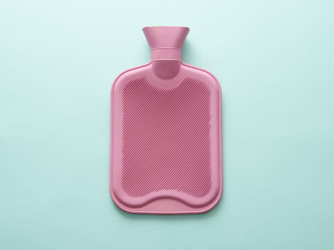 pink hot water bottle on blue background