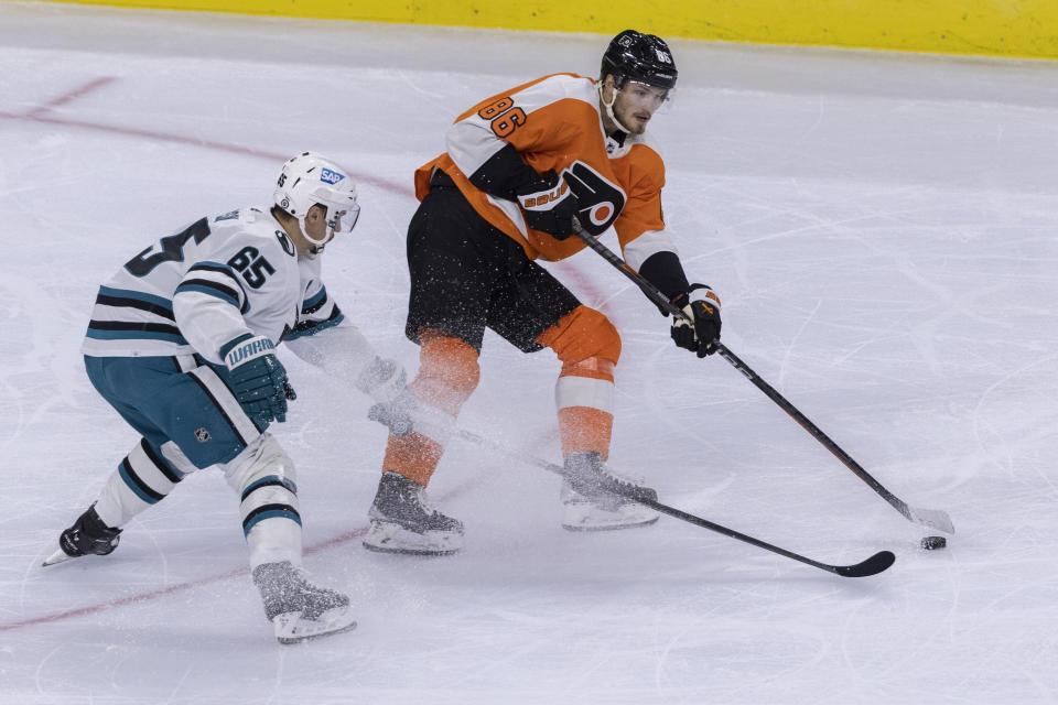 Philadelphia Flyers left wing Joel Farabee (86) moves the puck away from San Jose Sharks defenseman Erik Karlsson (65) during the first period of an NHL hockey game, Sunday, Oct. 23, 2022, in Philadelphia. (AP Photo/Laurence Kesterson)