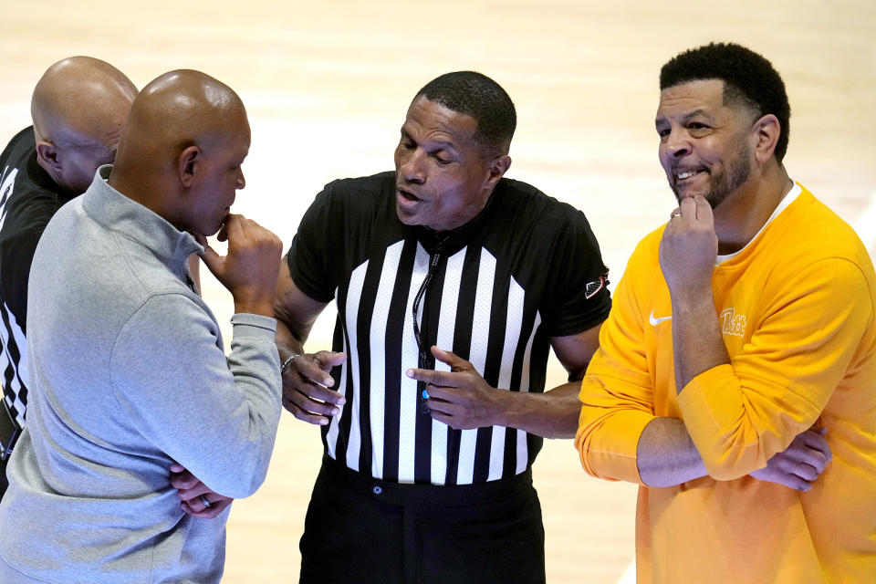 Pittsburgh coach Jeff Capel, right, and Syracuse coach Adrian Autry, left, listen to official Ted Valentine, center, explain offsetting fouls during the second half of an NCAA college basketball game in Pittsburgh Tuesday, Jan. 16, 2024. (AP Photo/Gene J. Puskar)