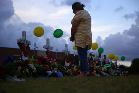 A mourner prays at a makeshift memorial left in memory of the victims killed in a shooting at Santa Fe High School in Santa Fe, Texas, U.S., May 21, 2018. REUTERS/Jonathan Bachman
