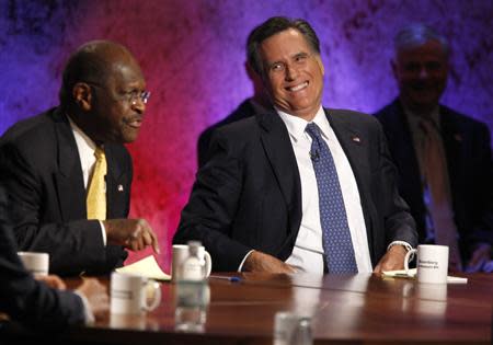 Republican presidential hopeful businessman Herman Cain speaks as former Massachusetts Governor Mitt Romney laughs at the Republican presidential debate at Dartmouth College in Hanover, New Hampshire October 11, 2011. REUTERS/Scott Eells/Pool