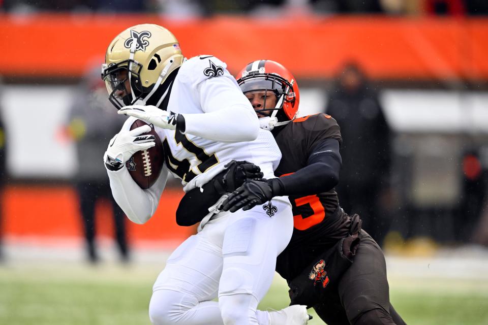 Cleveland Browns safety John Johnson III tackles New Orleans Saints running back Alvin Kamara (41) during the first half of an NFL football game, Saturday, Dec. 24, 2022, in Cleveland. (AP Photo/David Richard)