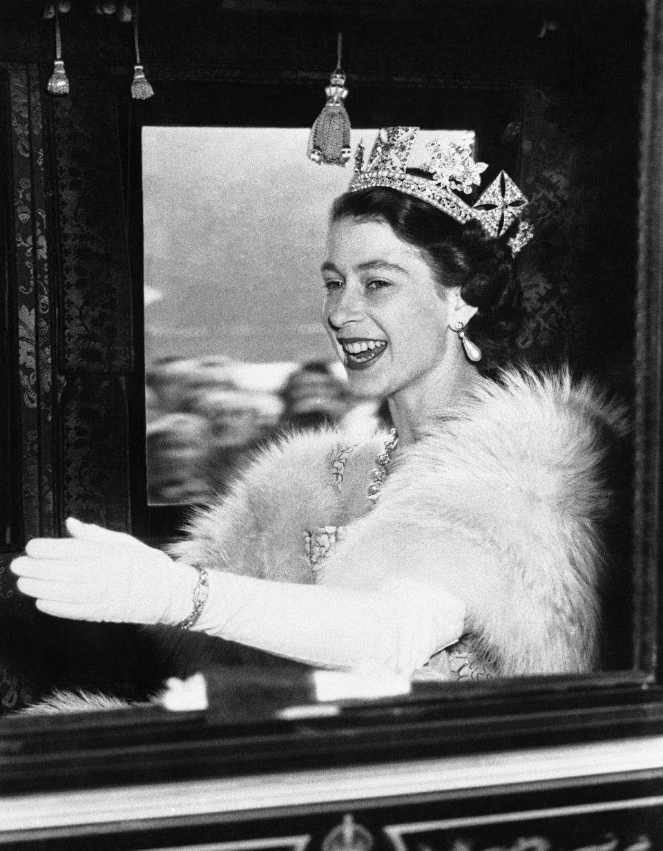 FILE - Britain's Queen Elizabeth II gestures from the Irish State coach as she travels to the House of Lords to open Parliament in London on Nov. 4, 1952. Queen Elizabeth II will mark 70 years on the throne Sunday, Feb. 6, 2022, an unprecedented reign that has made her a symbol of stability as the United Kingdom navigated an age of uncertainty. (AP Photo, File)