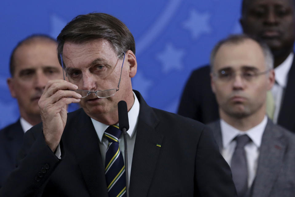 Brazil's President Jair Bolsonaro removes his glasses at the end of a press conference where he spoke on the resignation of Justice Minister Sergio Moro, at the Planalto Presidential Palace in Brasilia, Brazil, Friday, April 24, 2020. Moro, who became popular as a crusader against corruption, resigned on Friday, alleging political interference in the federal police force. (AP Photo/Eraldo Peres)