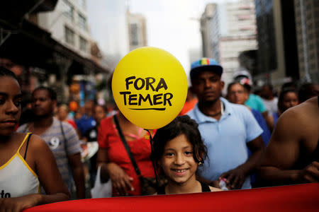 A girl holds a balloon that reads "Out Temer", referring to Brazil's President Michel Temer, during a protest against a constitutional amendment, known as PEC 55, that limits public spending, in Sao Paulo, Brazil, November 27, 2016. REUTERS/Nacho Doce