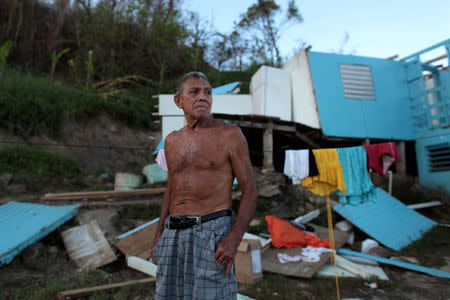 Ramon Sostre, stands in front of his damaged house after Hurricane Maria destroyed the town's bridge in San Lorenzo, Morovis, Puerto Rico, October 4, 2017. REUTERS/Alvin Baez
