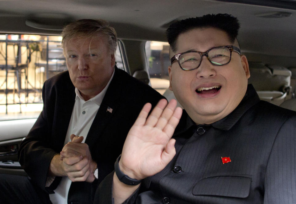 Howard X, right, an Australian impersonating North Korean leader Kim Jong Un, waves as Russel White, a U.S. President Donald Trump impersonator, gestures from a car outside La Paix hotel in Hanoi, Vietnam, Monday, Feb. 25, 2019. Take the reaction to the two impersonators who'd been posing for pictures with curious onlookers ahead of the second U.S.-North Korean summit. (AP Photo/Gemunu Amarasinghe)