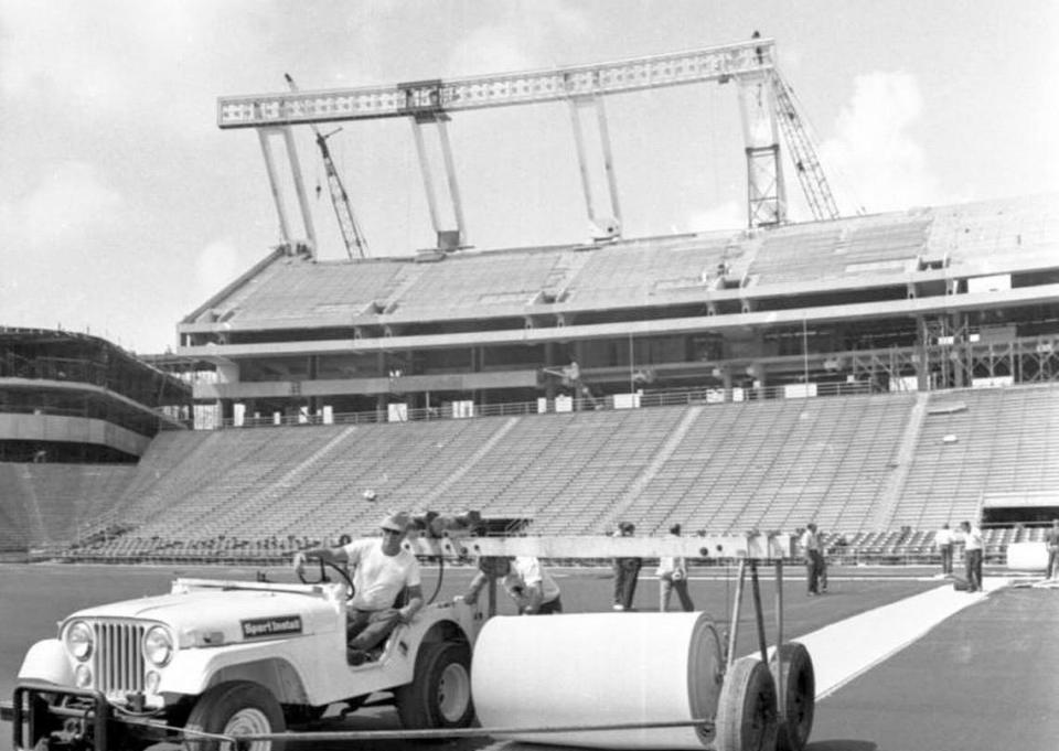 From 1971: Crews roll out a new AstroTurf surface at what was then known as Carolina Stadium. Construction of the upper west deck is visible in the background.