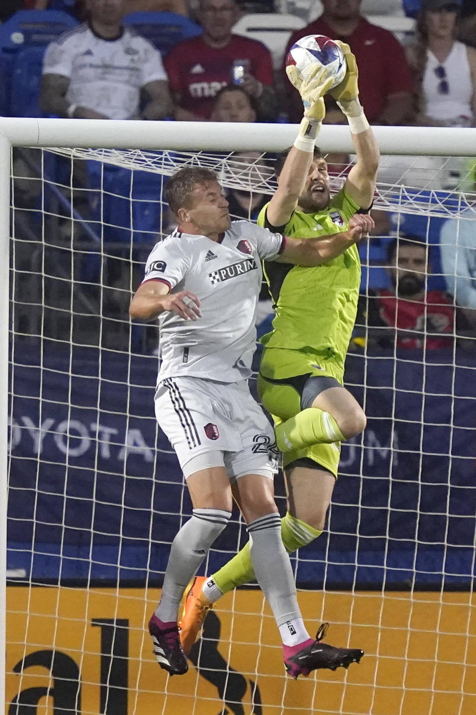 FC Dallas goalkeeper Maarten Paes (30) grabs the ball against Sporting Kansas City midfielder Erik Thommy (26) during the first half of an MLS soccer match Saturday, May 6, 2023, in Frisco, Texas. (AP Photo/LM Otero)