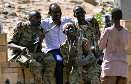 Sudanese military officers and a demonstrator pose for a photograph in celebration after Defence Minister Awad Ibn Auf stepped down as head of the country's transitional ruling military council, as protesters demanded quicker political change, near the Defence Ministry in Khartoum, Sudan April 13, 2019. REUTERS/Stringer