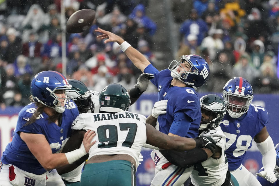 New York Giants quarterback Daniel Jones (8) takes a hit from Philadelphia Eagles linebacker Shaun Bradley (54) during the fourth quarter12 of an NFL football game, Sunday, Dec. 11, 2022, in East Rutherford, N.J. (AP Photo/John Minchillo)