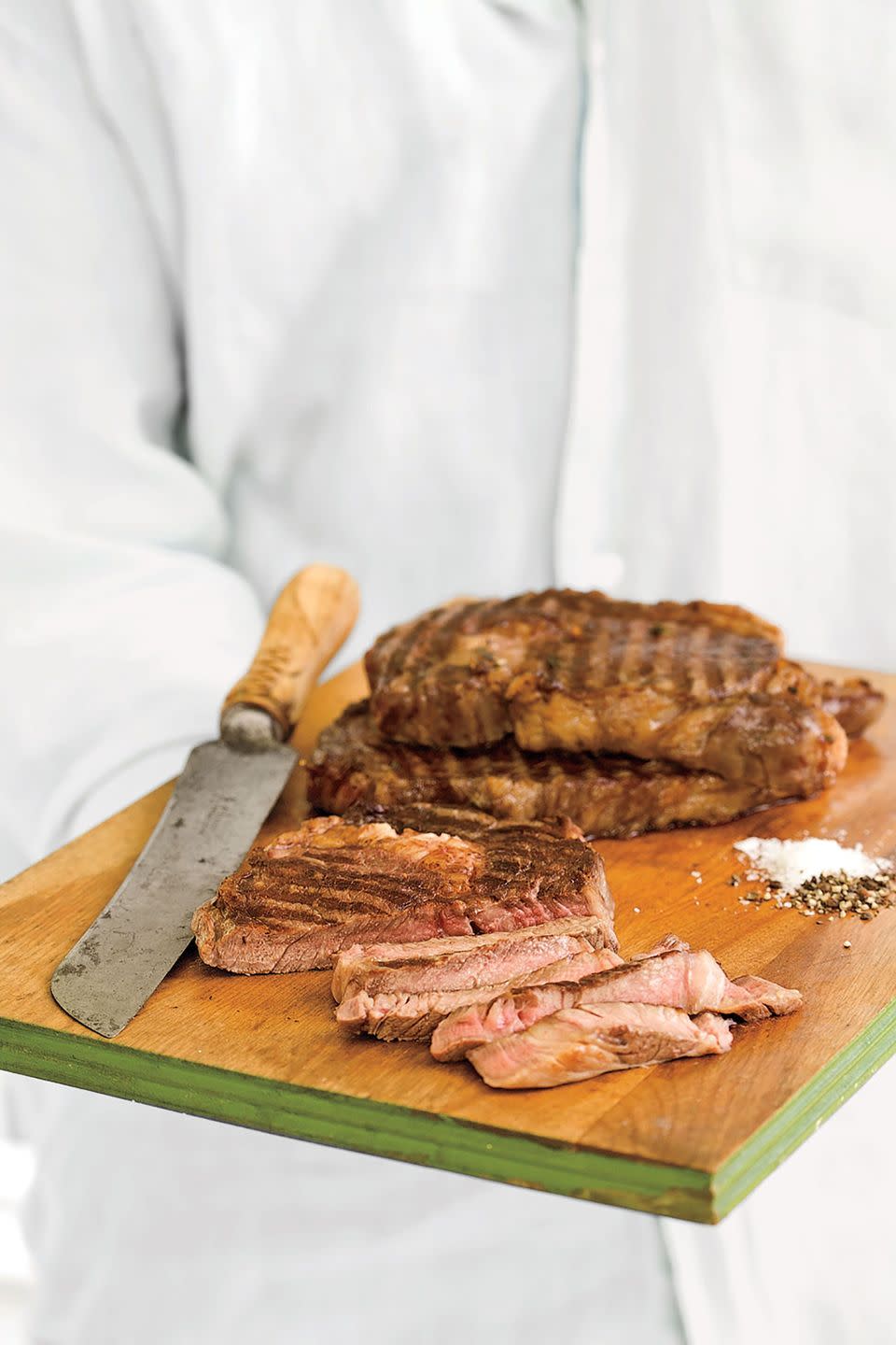 grilled ribeye steak on a wooden serving board