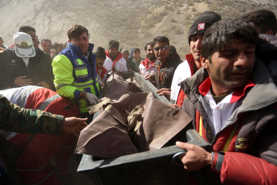 Medics and rescuers evacuate the body of a victim killed in a private plane crash in Iran, March 12, 2018. The crash killed 11 people, including a Turkish tycoon's daughter. (Photo: Tasnim News Agency / Reuters)