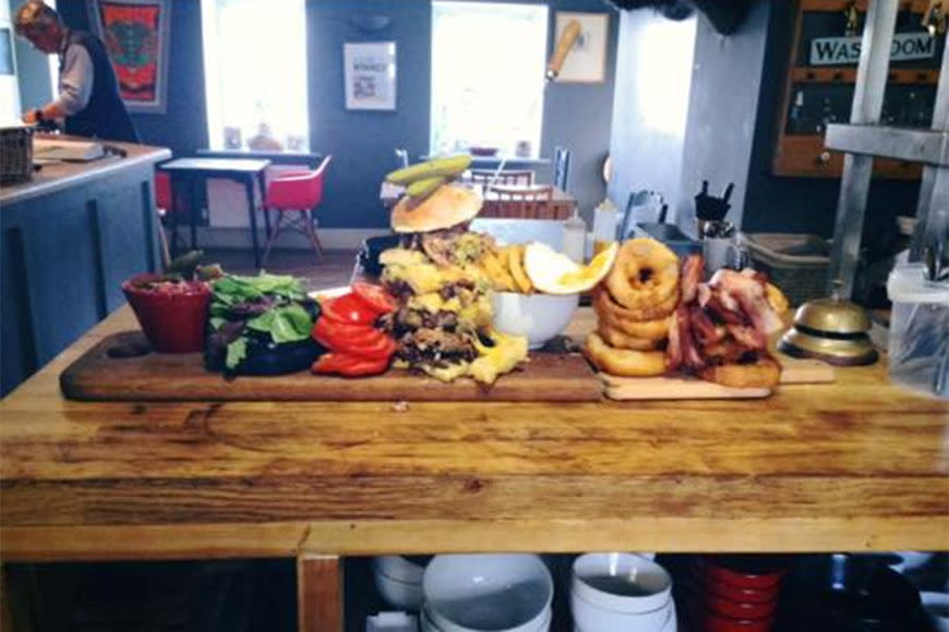 A chef at a British pub has created a monster 25,000kj burger. The Hog in Horsley head chef Dave Cameron makes the 30cm burger using more than 1kg of meat, 10 rashers of bacon and a couple of fried eggs. It’s served with 12 onions rings, about 500g of hot chips and a side salad. The burger will be available at the Gloucestershire local fete for around $20. However, there’s a catch – those you are unable to devour the humongous meal within 45 minutes will be penalised an additional $30.