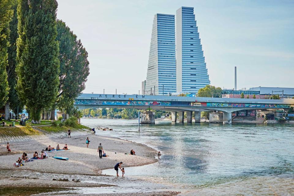 View of Switzerland's two tallest buildings from a beach on the banks of the Rhine River in Basel