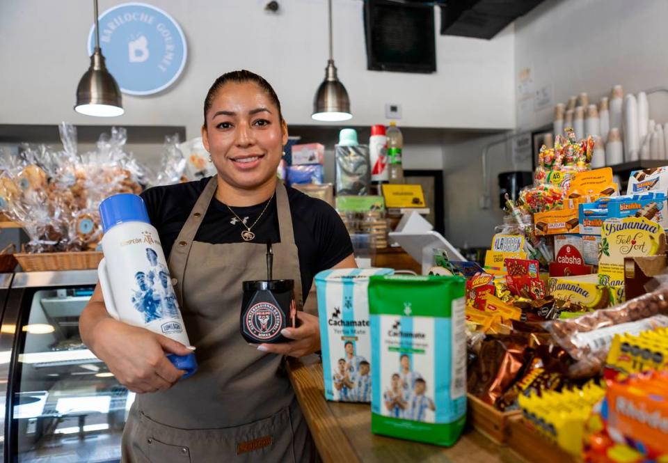 Pastora Paiz, an employee at the Bariloche Gourmet bakery, is photographed next to different Lionel Messi themed mate products up for sale at the store on Wednesday, July 12, 2023, in Miami, Fla.
