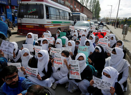 Schoolgirls holding placards sit in a road during a protest against the rape of an eight-year-old girl in Kathua, near Jammu, a teenager in Unnao, Uttar Pradesh, and an eleven-year-old girl in Surat, Gujarat, in Srinagar April 17, 2018. REUTERS/Danish Ismail