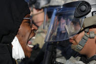 Protesters and National Guardsmen face off on East Lake Street, Friday, May 29, 2020, in St. Paul, Minn. The massive protests sweeping across U.S. cities following the police killing of a black man in Minnesota have elevated fears of a new surge in cases of the coronavirus. Images showing thousands of screaming, unmasked protesters have sent shudders through the health community, who worry their calls for social distancing during the demonstrations are unlikely to be heard. (AP Photo/John Minchillo)