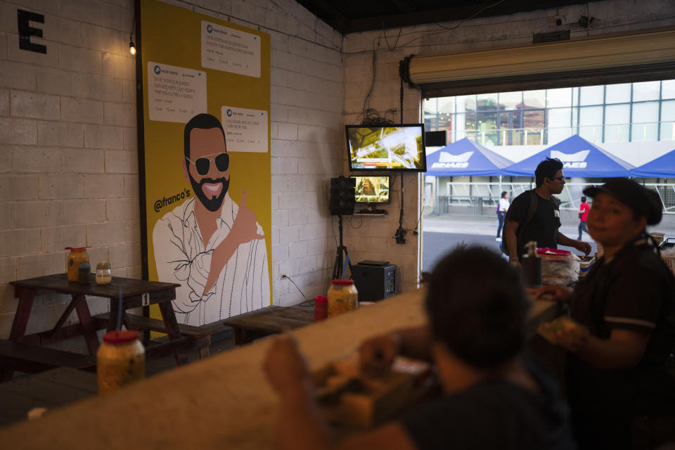 Patrons sit at a food store decorated with a mural of El Salvador President Nayib Bukele, who is running for re-election, in downtown San Salvador, El Salvador, Monday, Jan. 29, 2024. El Salvador will hold a general election on Feb. 4. (AP Photo/Moises Castillo)