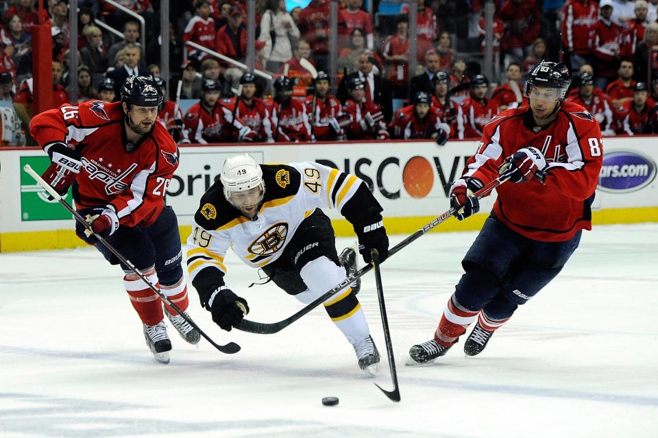 WASHINGTON, DC - APRIL 22: Matt Hendricks #26 and Jay Beagle #83 of the Washington Capitals battle for the puck with Rich Peverley #49 of the Boston Bruins in Game Six of the Eastern Conference Quarterfinals during the 2012 NHL Stanley Cup Playoffs at Verizon Center on April 22, 2012 in Washington, DC. Hendricks was called for a two minute penalty for tripping Peverley. (Photo by Patrick McDermott/Getty Images)