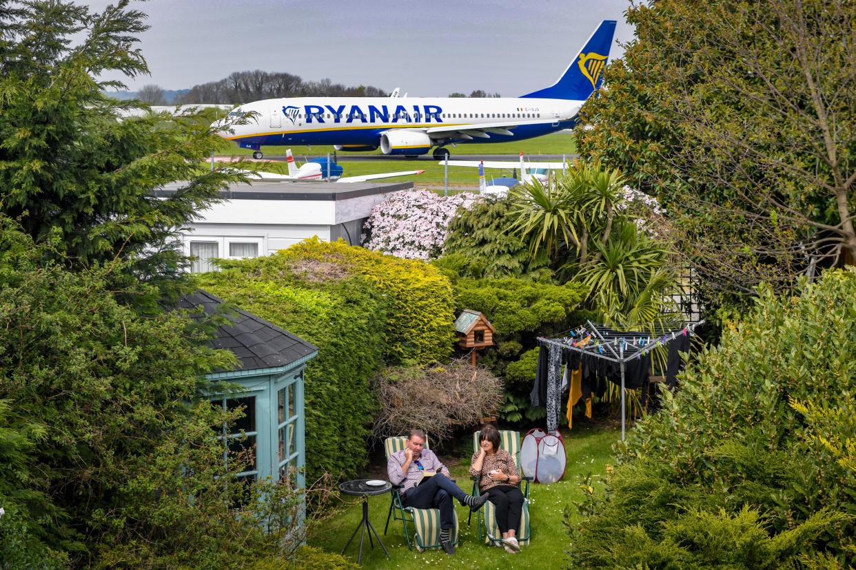 Ms Marchants neighbours, Alex and June Carr in their garden which backs on to Southend Airport in Essex. (SWNS)