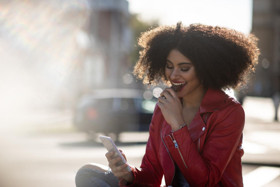 Woman eating chocolate with good teeth. (Getty Images)